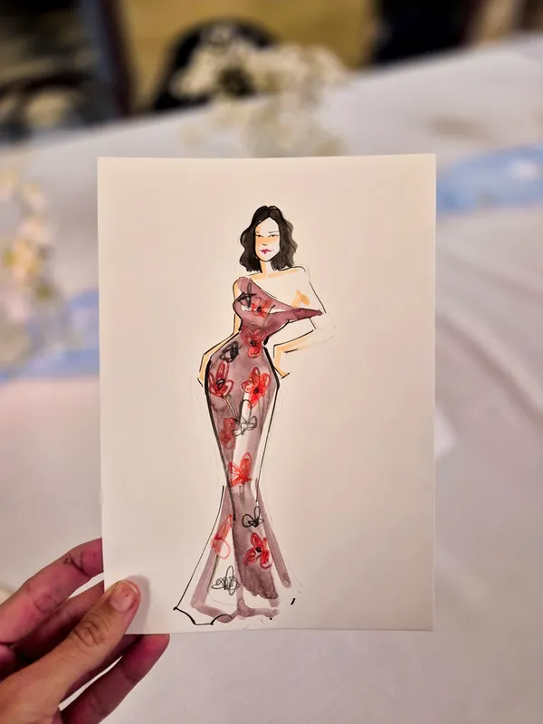 Live watercolour portrait of a wedding guest in a fitted red floral gown by Alisha Milajew