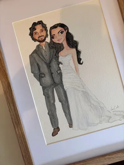 Framed watercolour illustration of a bride and groom in a strapless gown and grey suit, by Lisa Catanea
