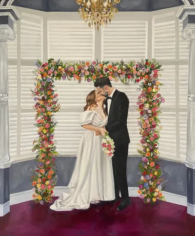 Live acrylic and oil wedding painting of a couple kissing under a colourful floral arch by Your Wish I Paint